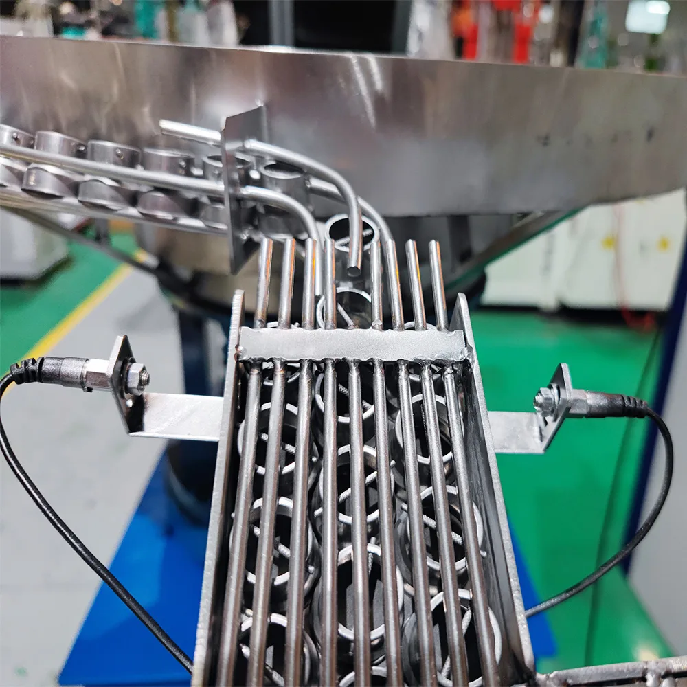 Metal lamp caps positioned in parallel feed tracks